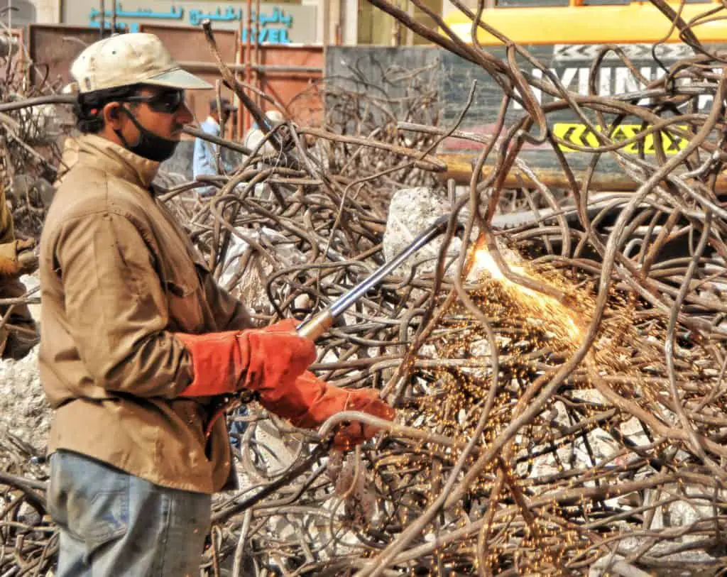 Man In Metal Scrap Wearing Gloves